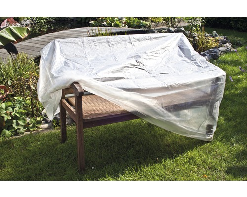 Zahradní lavice zakrytá průhlednou ochrannou plachtou na zahradě