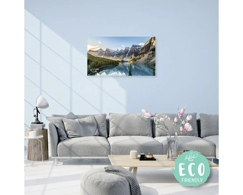 Obývací pokoj s pohovkou a zarámovaným obrazem horské krajiny s jezerem