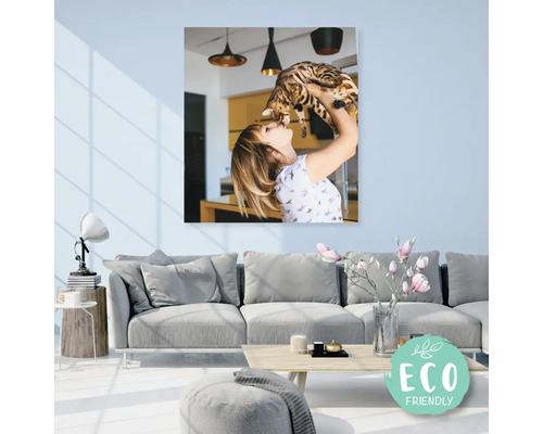 Plátno zobrazující ženu držící kočku, v pozadí obývací pokoj