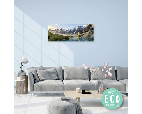 Obývací pokoj s pohovkou a nástěnnou dekorací horské krajiny