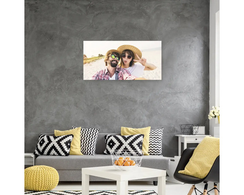 Obývací pokoj s pohovkou, polštáři a fotografií na zdi