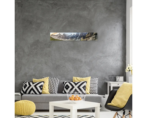 Obývací pokoj s pohovkou, polštáři, stolem a panoramatickým obrazem horské krajiny