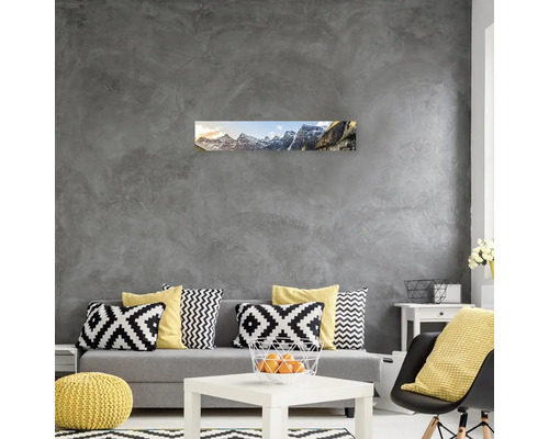 Obývací pokoj s pohovkou, polštáři, stolem a nástěnnou malbou s horským motivem