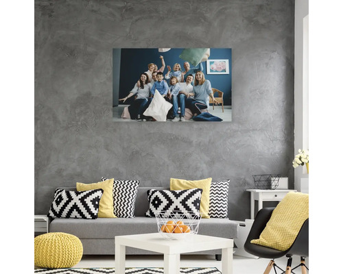 Obývací pokoj s pohovkou, polštáři a nástěnnou malbou zobrazující rodinu, která hraje polštářovou bitvu.