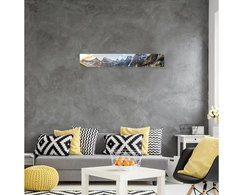 Obývací pokoj s pohovkou, stolem a nástěnnou malbou horské krajiny