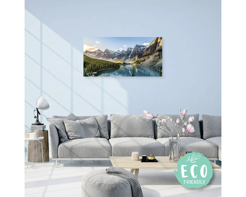 Obývací pokoj s pohovkou a nástěnnou malbou s motivem horského jezera