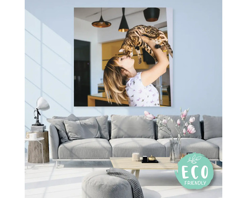 Plátno s obrazem ženy držící kočku nad pohovkou v obývacím pokoji