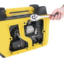 Otevřený kryt zařízení generátoru elektrické energie s rukou držící klíč