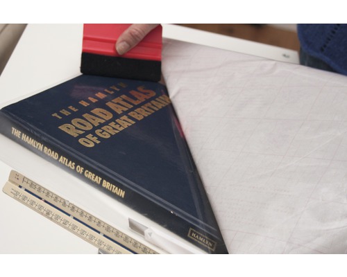 Ochranná fólie na knihy se nanáší stěrkou na autoatlas