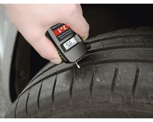 Ruka měří hloubku dezénu pneumatiky pomocí digitálního hloubkoměru dezénu