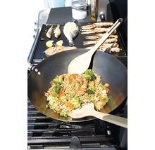 Wok se zeleninou a krevetami a také ryby a mořské plody připravované na grilu.