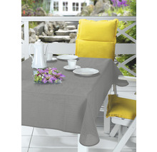 Prostřený stůl venku s šedým ubrusem, nádobím a květinovou výzdobou