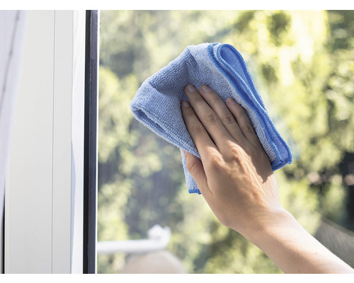 Ruka čistí okno hadříkem z mikrovlákna.