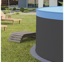 Zahradní pohled s kulatým bazénem a dřevěnými lehátky na trávníku