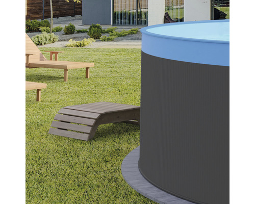 Zahradní pohled s kulatým bazénem a dřevěnými lehátky na trávníku