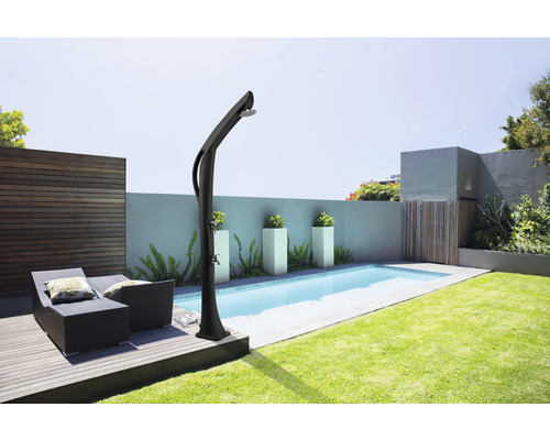 Scéna zahrady s bazénem, lehátky a zahradní sprchou.