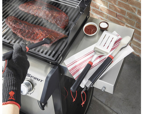 Příprava masa na grilu s grilovacím náčiním, marinádou a grilovací rukavicí