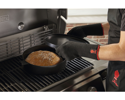 Pečení chleba v litinovém hrnci na grilu s grilovacími rukavicemi a zástěrou