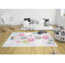 Herní místnost s kobercem se vzorem čísel, bílým houpacím křeslem a plyšovými zvířaty