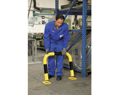 Muž montuje žlutočernou ochranu proti nárazu před regál