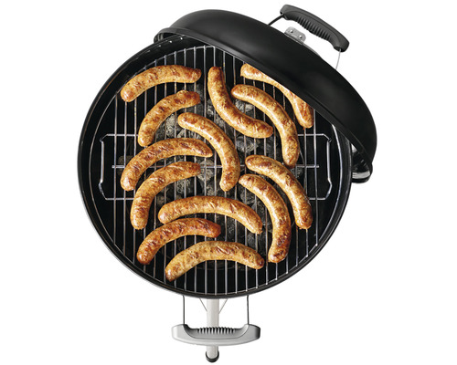 Kulatý gril s klobásami na grilovací mřížce