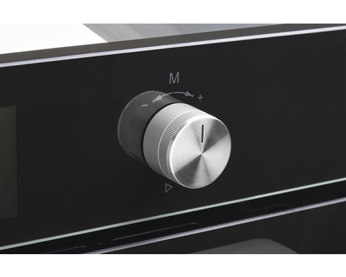 Detailní záběr otočného knoflíku na troubě pro ovládání funkcí a teploty