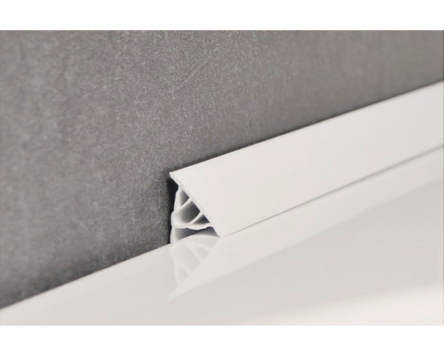 Bílá plastová soklová lišta na zdi a podlaze