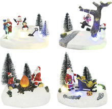 Různé vánoční dekorace s figurkami a stromy na zasněženém podkladu.