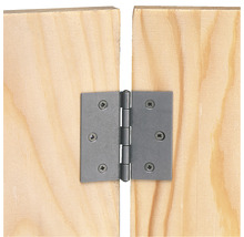 Kovové dveřní kování připevněné na dřevěných dveřích