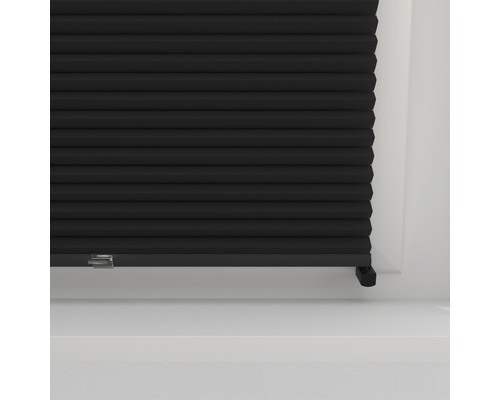 Detail černého plisovaného závěsu na okně