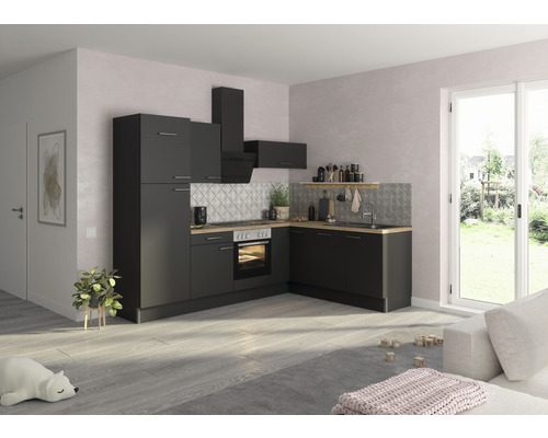 Světlý byt s moderní černou kuchyňskou linkou, digestoří a pracovní deskou s dřevěným vzhledem.