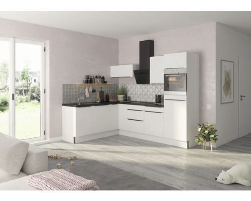 Světlá kuchyně s bílými skříňkami, digestoří a dřezem před vzorovanou zadní stěnou