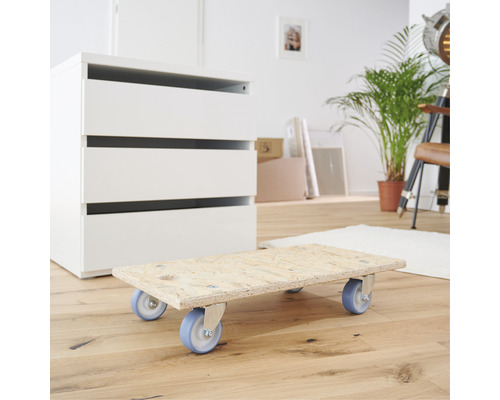 Přepravní kolečko s kolečky před komodou v pokoji