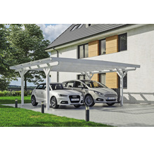 Dva automobily pod bílým dřevěným přístřeškem pro auto před domem.