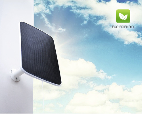 Solární lampa namontovaná na zdi před oblohou s mraky. Symbol: šetrné k životnímu prostředí.