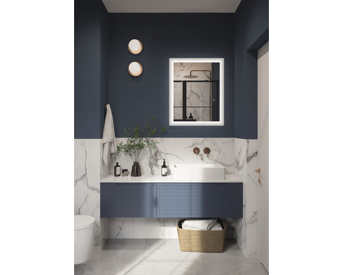 Moderní koupelna s umyvadlem, osvětleným zrcadlem a dekoracemi