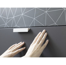 Detail nábytku s geometrickým vzorem a úchytkou zásuvky