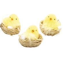 Tři žlutá kuřátka v hnízdě s vejcem jako velikonoční dekorace