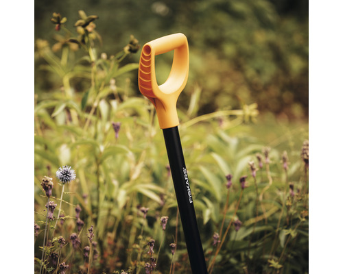 Rýč Fiskars na zahradě před rostlinami