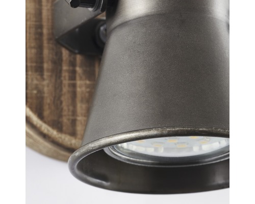 Detailní pohled na nástěnné svítidlo s kovovými prvky a dřevěným akcentem