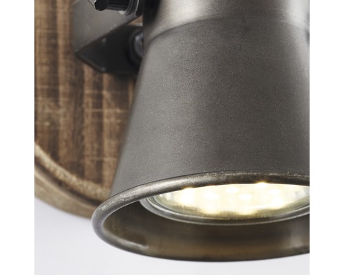 Detail nástěnné lampy s dřevěnou základnou a kovovou hlavou