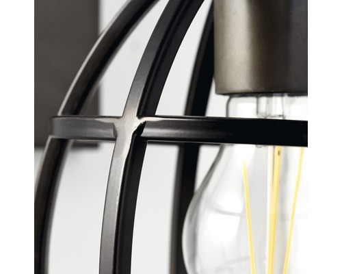 Detailní záběr lampy s klecovým stínidlem a žárovkou