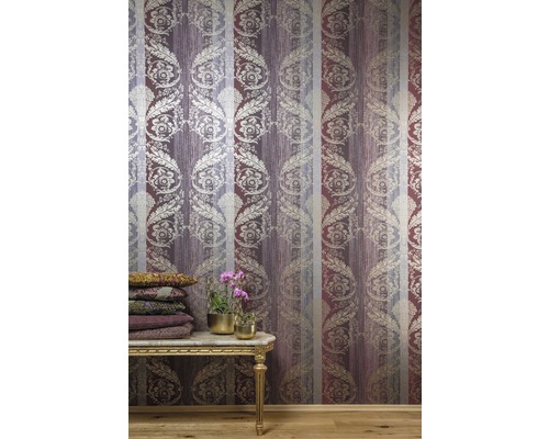 Dekorativní pokoj s vzorovanou tapetou, stolem a rostlinami.