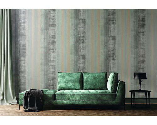 Obývací pokoj s pruhovanou tapetou, pohovkou a stolní lampou