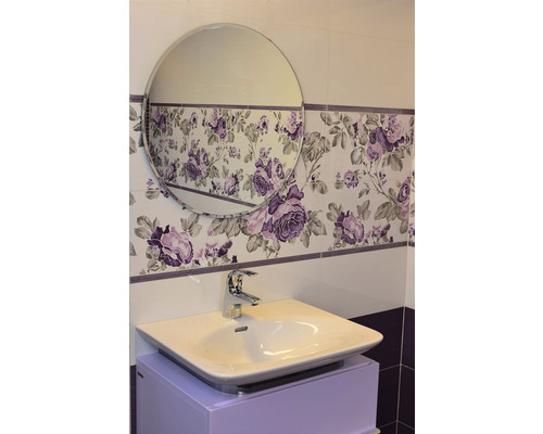 Koupelna s umyvadlem, baterií a zrcadlem před obkladem s květinovým vzorem