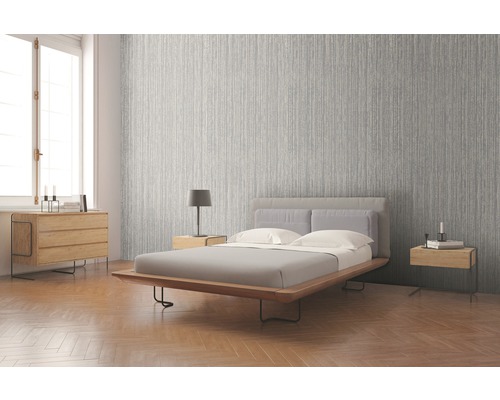 Světlá ložnice se vzorovanou tapetou, postelí a nočními stolky.