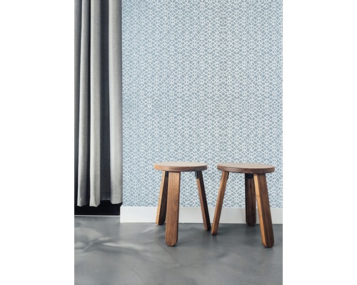 Dvě dřevěné stoličky před vzorovanou tapetou a závěsem