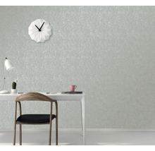 Kancelář se stolem, židlí a designovými hodinami před strukturovanou tapetou