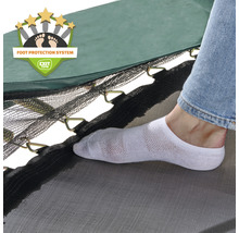 Detailní záběr trampolíny se systémem ochrany nohou a osoby v ponožce.