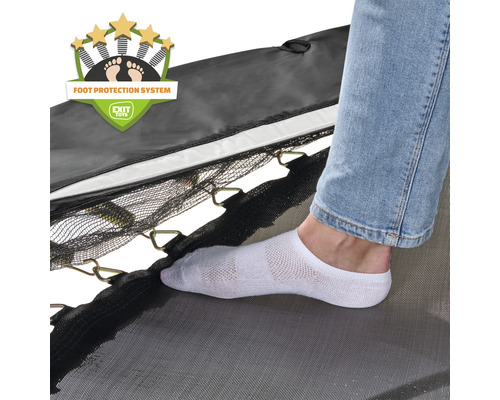 Detailní záběr trampolíny se systémem ochrany nohou a osoby v ponožkách na skákací plachtě